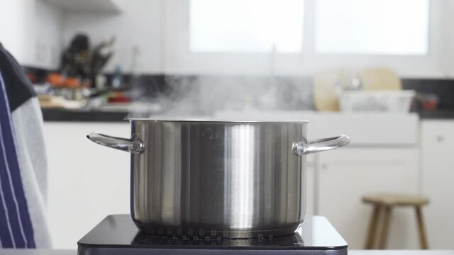Chef adding salt to steam pot