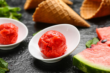 Bowls with watermelon ice cream on dark background