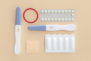 Different contraceptives and pregnancy tests on color background