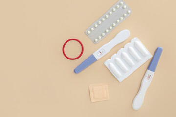 Different contraceptives and pregnancy tests on color background