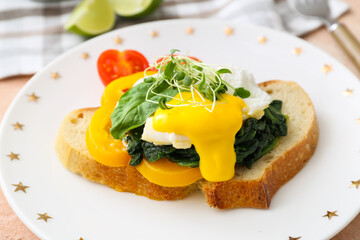 Tasty sandwich with florentine egg and fresh vegetables on plate, closeup