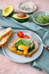 Tasty breakfast with florentine egg and fresh vegetables on color background
