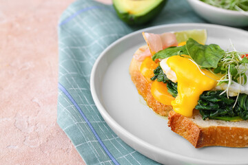 Tasty sandwich with florentine egg on color background, closeup