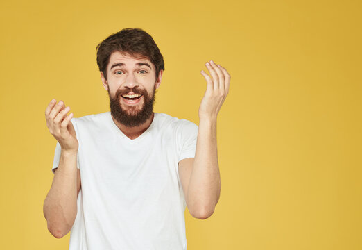 Portrait of a man on a yellow background gesturing with his hands emotions yellow background Copy Space
