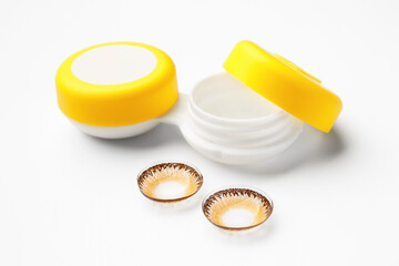 Container with contact lenses on white background