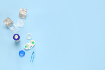 Tweezers, contact lenses and containers on color background