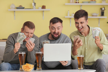 Happy men after winning of their sports bet at home