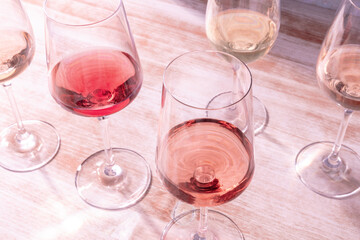 Rose wine tasting, a party, many glasses on a wooden background