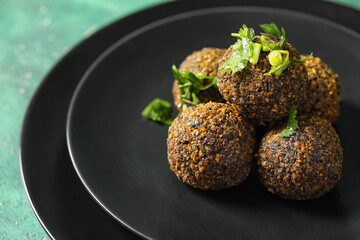 Plate with tasty falafel balls on color background
