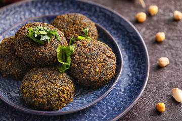 Plate with tasty falafel balls on dark background