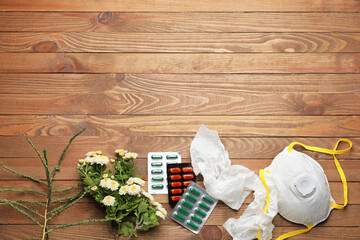 Composition with pills, flowers and respirator on wooden background