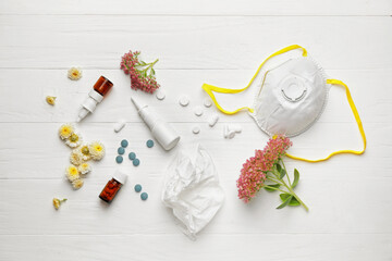 Composition with bottles of drops, flowers and respirator on light wooden background