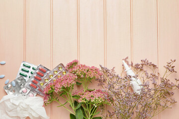Composition with pills, flowers and used tissue on color wooden background