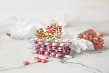 Pills, flowers and used tissue on light background