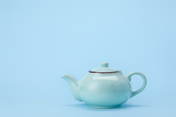 Stylish teapot on color background