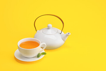 Stylish teapot and cup of tea on color background