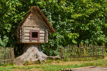 Fairy Hut of Grandmother Yaga Standing on Chicken Legs and covered with green foliage of trees