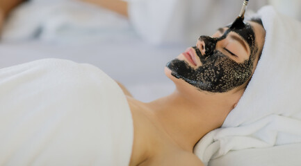 Beautiful woman sleep for wait brush a facial mask with herb cream for well face skin and covered warp by a white towel on head and her body