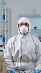 Lab technician in ppe suit working with virtual reality in chemical laboratory. Team of biologists examining vaccine evolution with high tech and technology researching treatment against covid19 virus