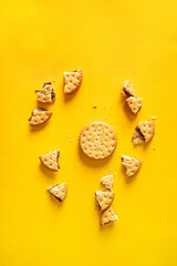 Sandwich biscuits cookies with chocolate filling and crumbs on yellow background
