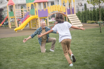 Fototapeta premium Boy running to his dads open arms and looking happy