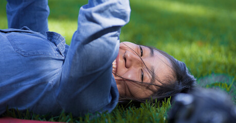 Teenage girl smiling at the camera lying in a park