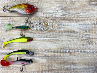 Fishing tackle. Float, wobbler, bait hooks, on a wooden background. Selective focus
