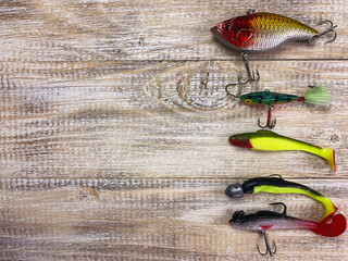 Fishing tackle. Float, wobbler, bait hooks, on a wooden background. Selective focus