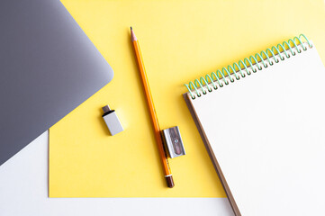 Desktop. Stationery and laptop on yellow background. Ultimate Gray and yellow. Panton colors 2021.