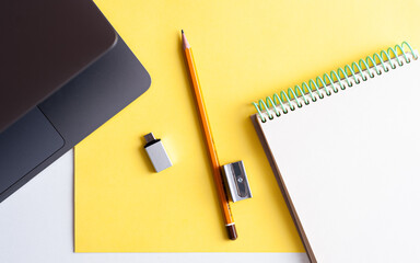 Desktop. Stationery and laptop on yellow background. Ultimate Gray and yellow. Panton colors 2021.