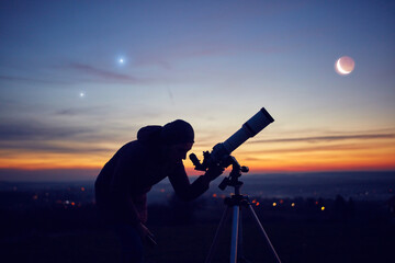 Woman looking at night sky with amateur astronomical telescope.