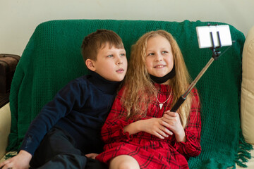 Children bloggers - a boy and a girl of 8-10 years old are broadcasting, looking at the phone