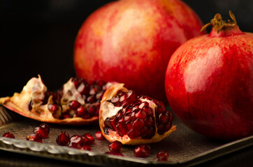 pomegranate and whole with garnet grains in a bow