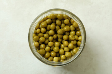 Jar of canned peas on white textured background