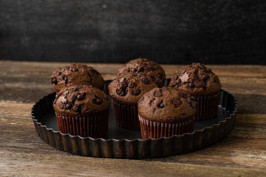 Chocolate cupcake with chocolate drops. Rustic wood background