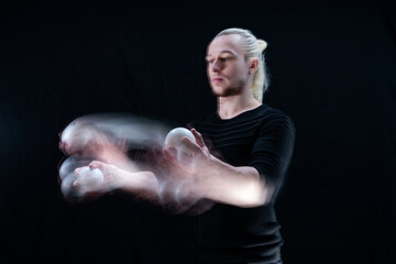 Abstract image of juggler with smoothed white balls in motion 