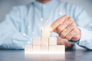 Businessmen use a handle on the wooden block to show stock graphs and rising stock signals with chart indicators. Concepts of financial interest rates and mortgage rates.