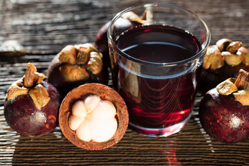 Fresh Mangosteen fruit and drink in jar on wooden background