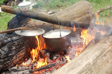 Cooking on an open fire in field conditions. Boiling water in the bowler on the bonfire. Close-up....
