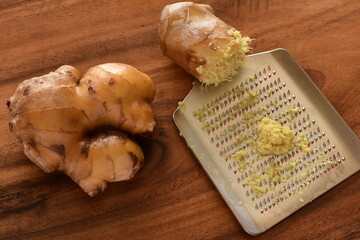 Fresh grated ginger on wooden board.