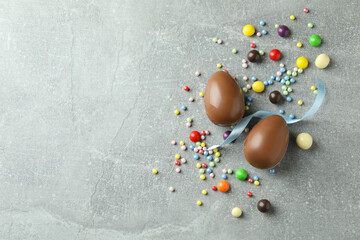 Easter chocolate eggs and candies on gray background