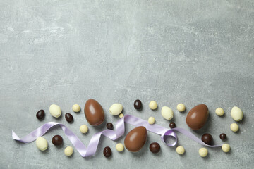 Easter chocolate eggs and candies on gray background