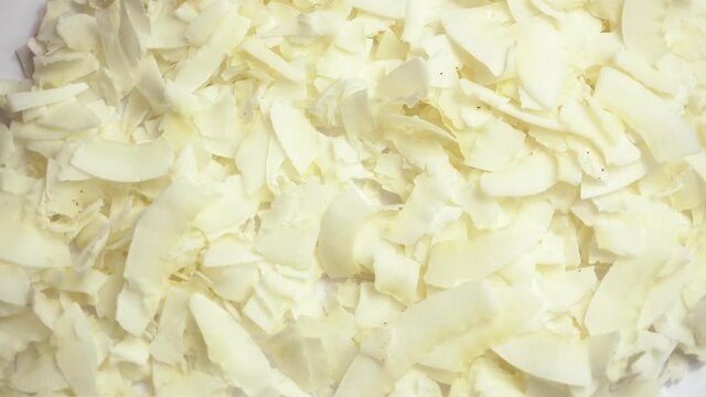 Rotating video of dry flakes cocos over white background.