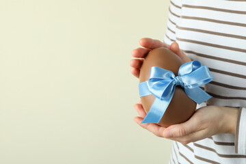 Woman hold chocolate egg with blue ribbon, space for text