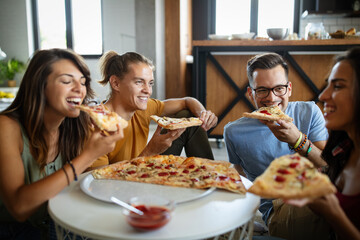 Group of friends having party at home, eating pizza and having fun.