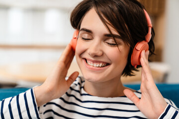 Happy beautiful girl smiling while listening music with headphones