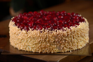Raspberry cake with nuts on wooden table