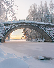 Old stone bridge middle of snow on sunset light
