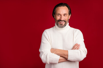 Photo of mature handsome happy smiling cheerful businessman look copyspace with crossed hands isolated on red color background