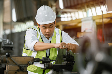 Asian engineering man wearing uniform safety worker perform maintenance in factory working machine lathe metal, Heavy industry worker man concept.